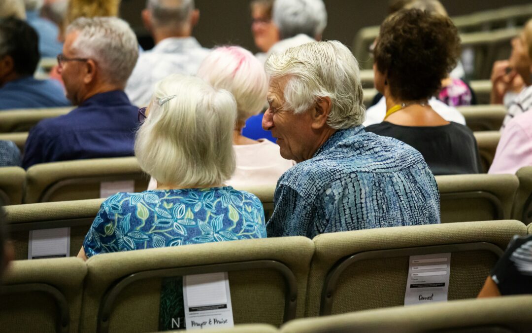 Seniorinnen und Senioren sitzen bei einer Veranstaltung im Publikum